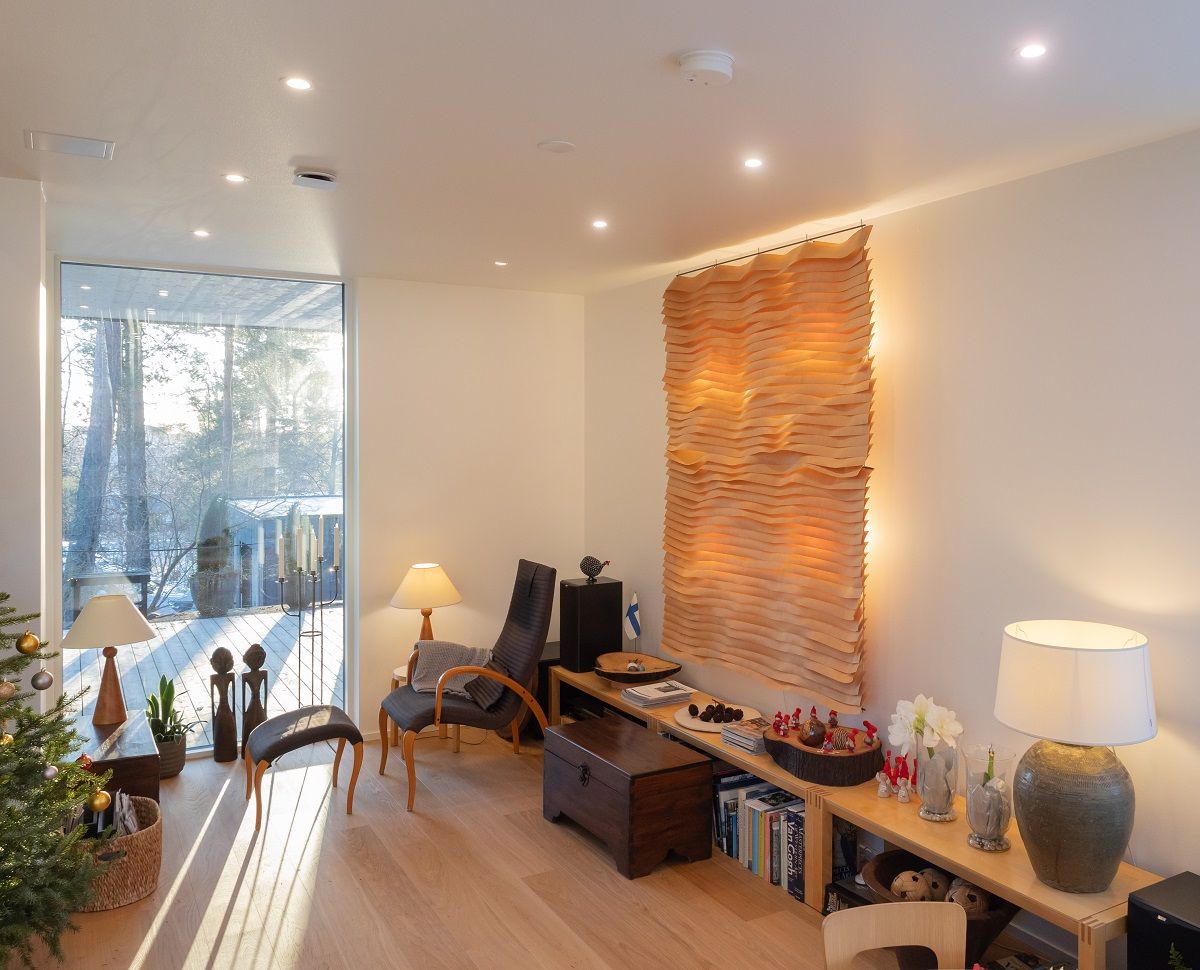 The living room is lit symmetrically with flush-mounted ceiling lights and complemented by decorative table lamps.